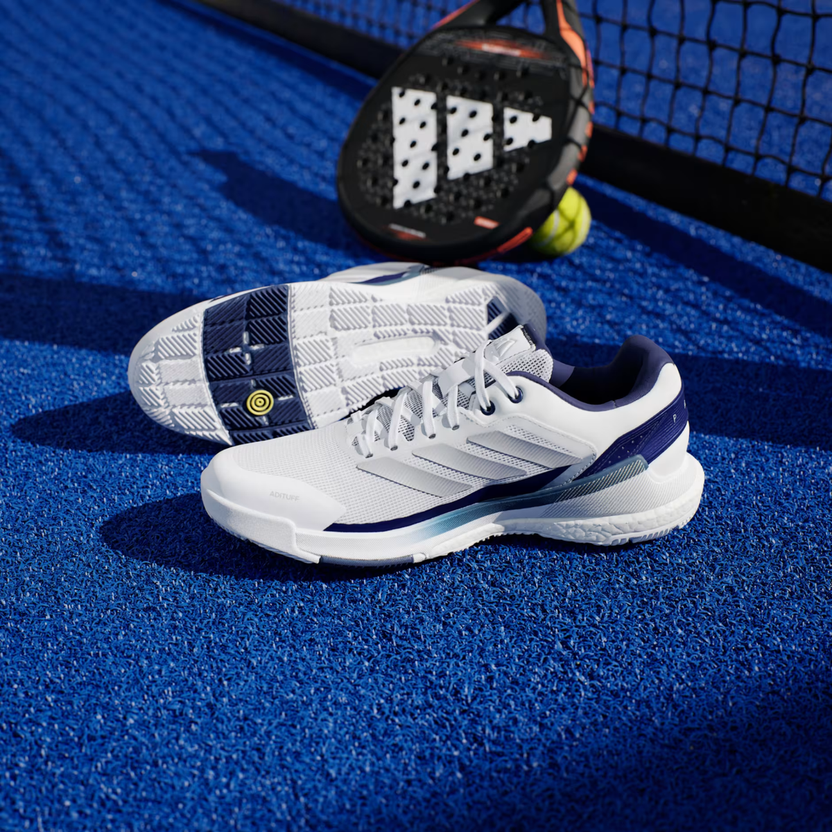 Adidas Crazyquick Boost padel shoes, pair on court showing the upper and three stripes