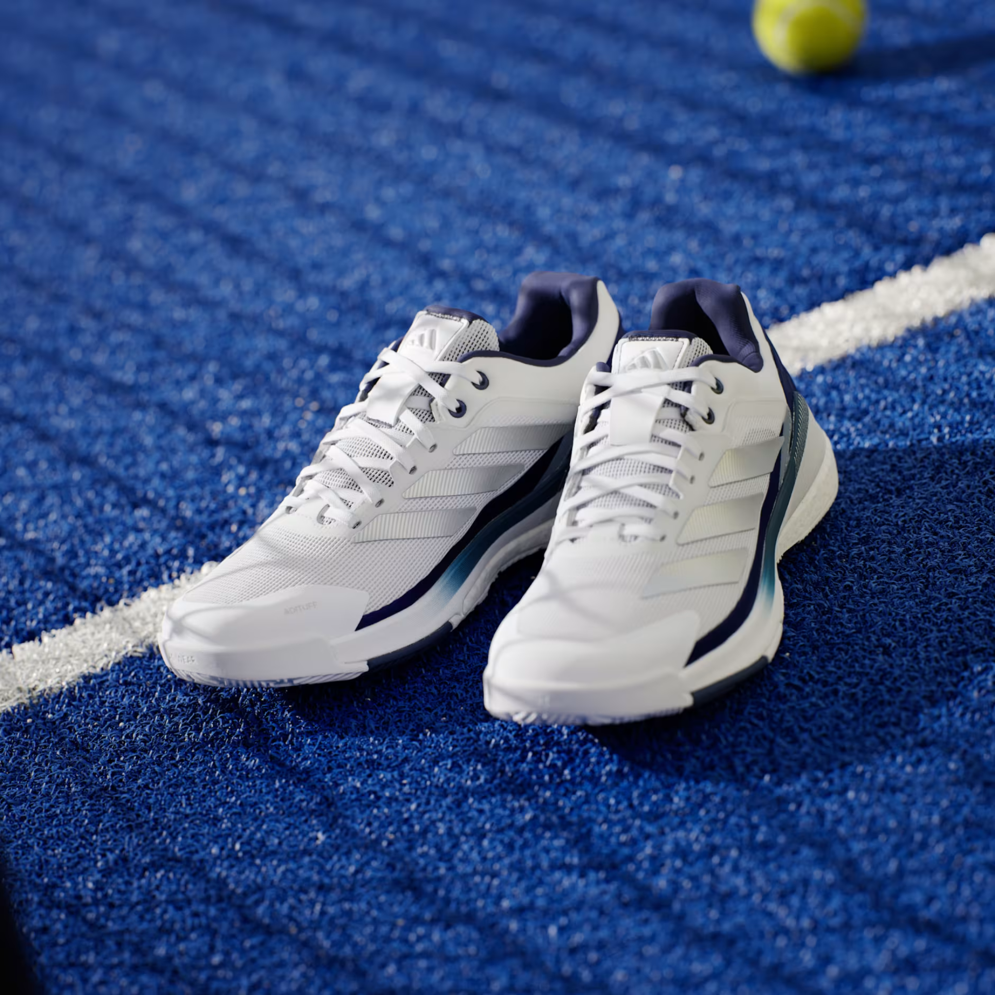 Adidas Crazyquick Boost padel shoes, pair resting on the court line